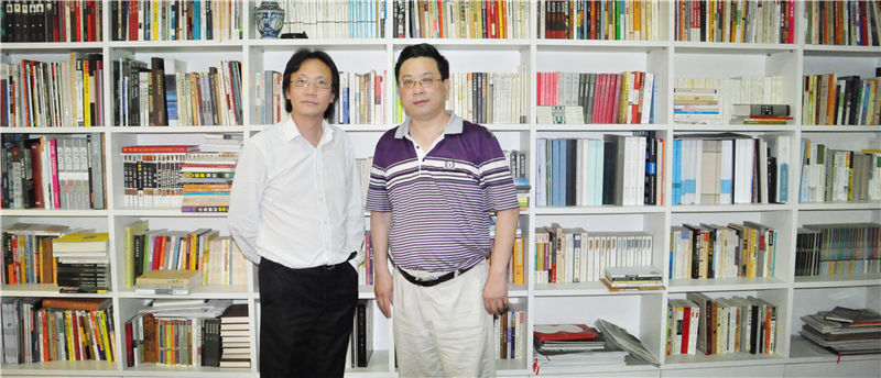 企业家日报副社长吴礼明(右)拜访上海世贸控股集团董事长李焱然(右)并在其书柜前合影